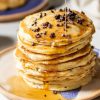 Chocolate Chip Protein Pancakes with syrup being drizzled on top.