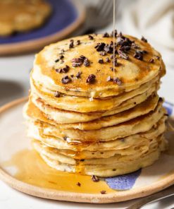 Chocolate Chip Protein Pancakes with syrup being drizzled on top.